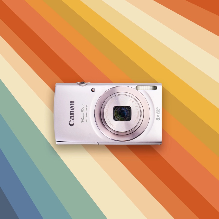 A silver Canon PowerShot ELPH 135 on a striped background