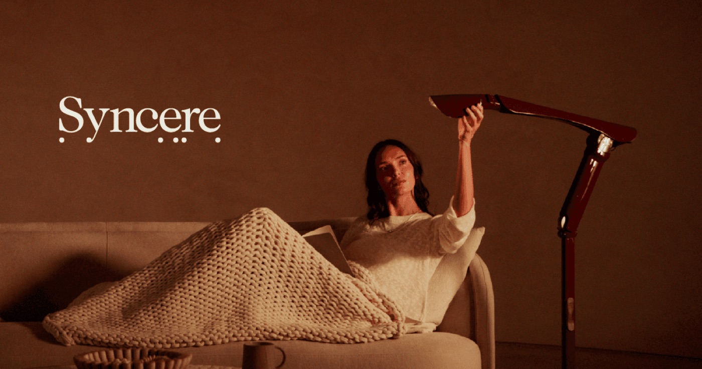The articulated Syncere Lume robotic lamp beside a person on a sofa